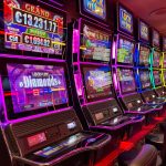 Máquinas caça-níqueis coloridas alinhadas em um cassino iluminado, com painéis de jackpot ao fundo.