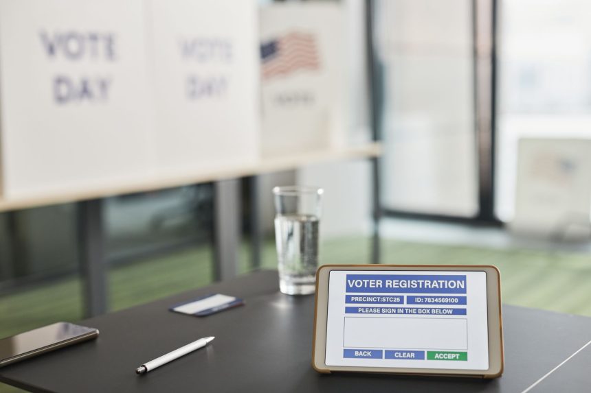 Tablet exibe uma tela de cadastro eleitoral em uma seção de votação interna, com sinalização relacionada ao dia da eleição.