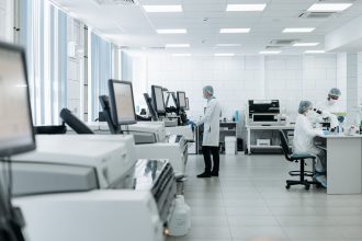 Pesquisadores trabalham em um laboratório equipado com instrumentos científicos e tecnologia avançada.